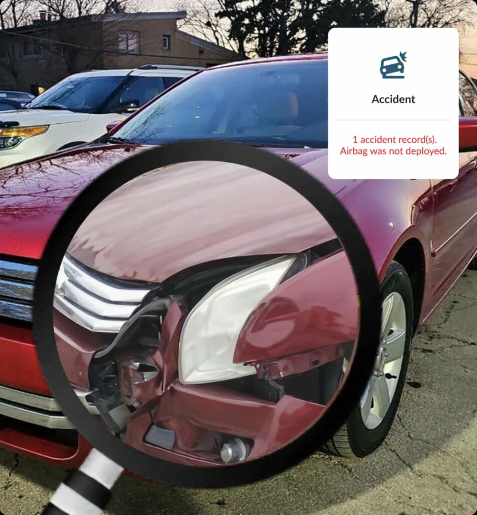 Magnified view of red car front damage illustrating accident history by VIN record.